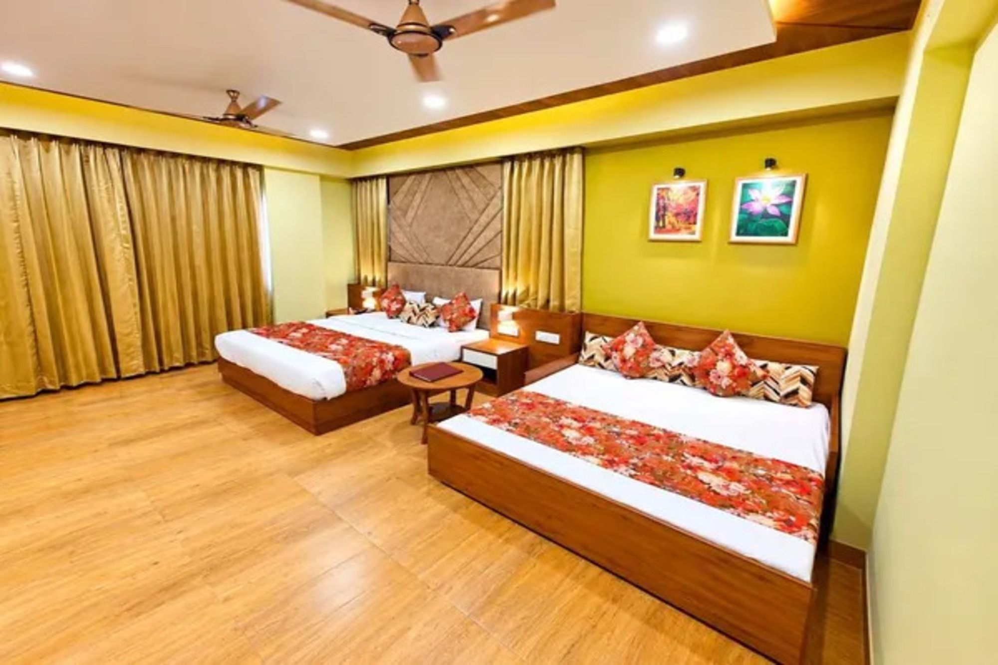 A hotel room with two beds, a ceiling fan, and a small table.