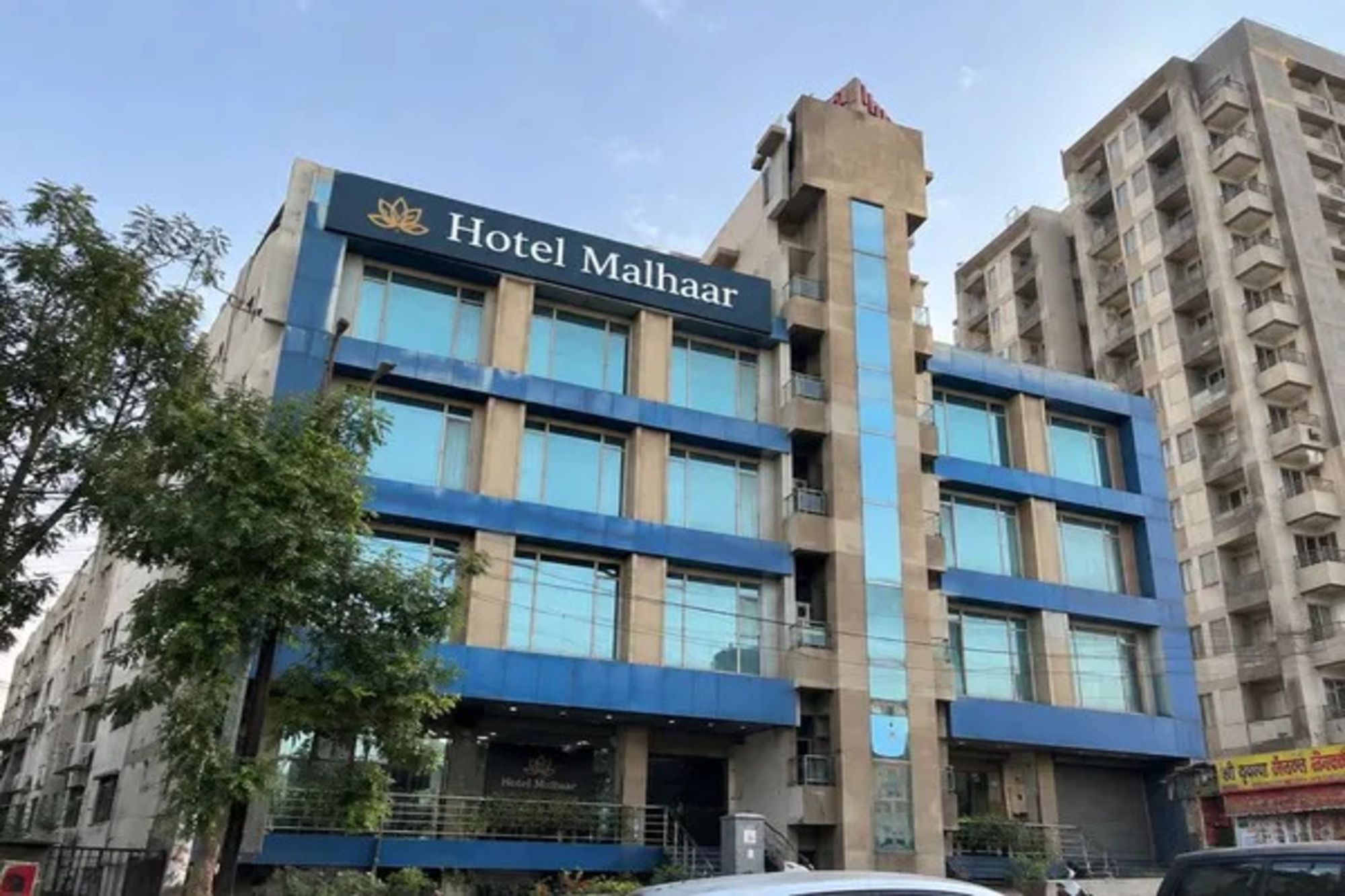 A multi-story hotel building with a prominent sign reading 'Hotel Malhaar.'