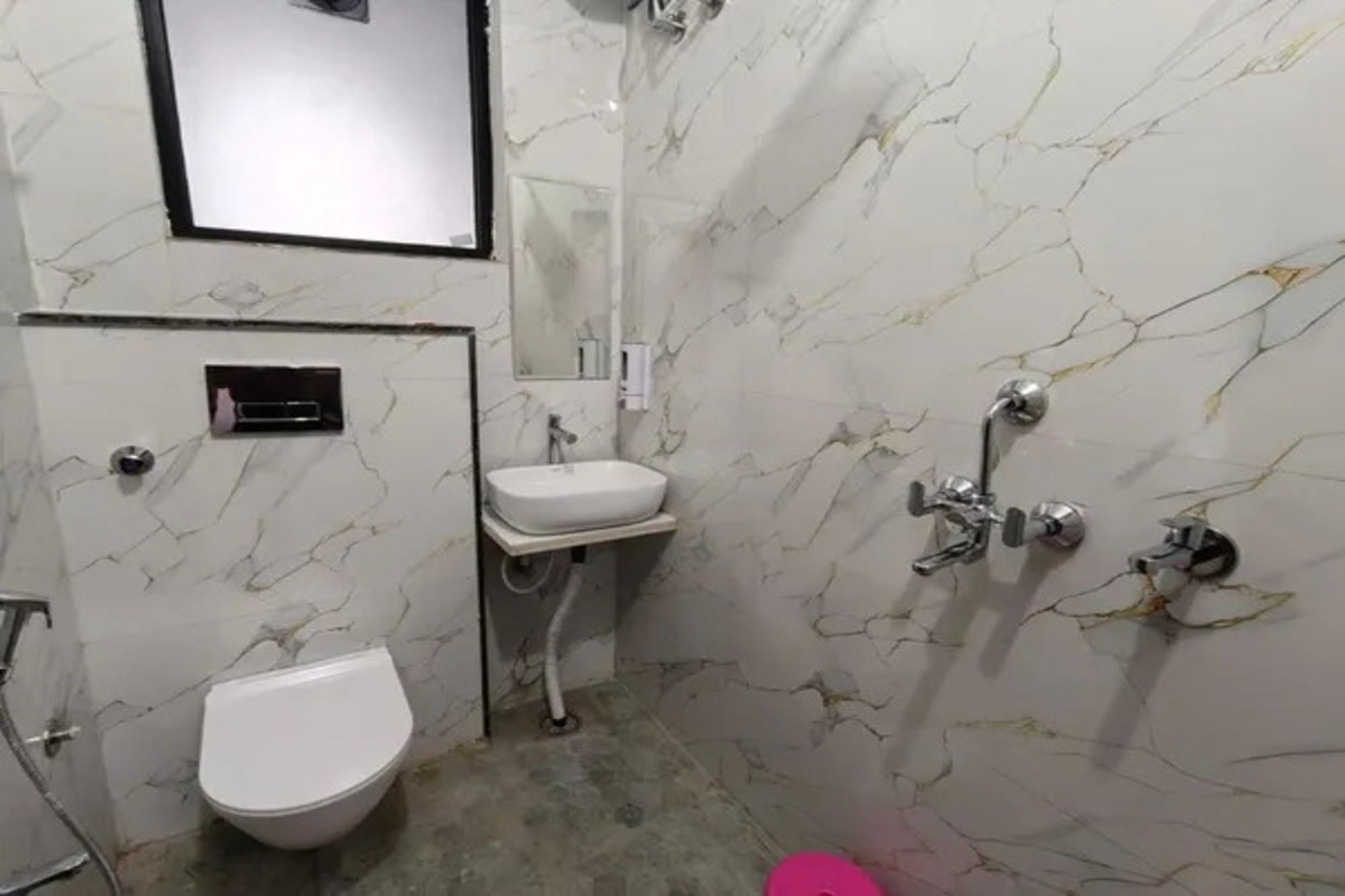 A bathroom with a toilet, sink, and shower.