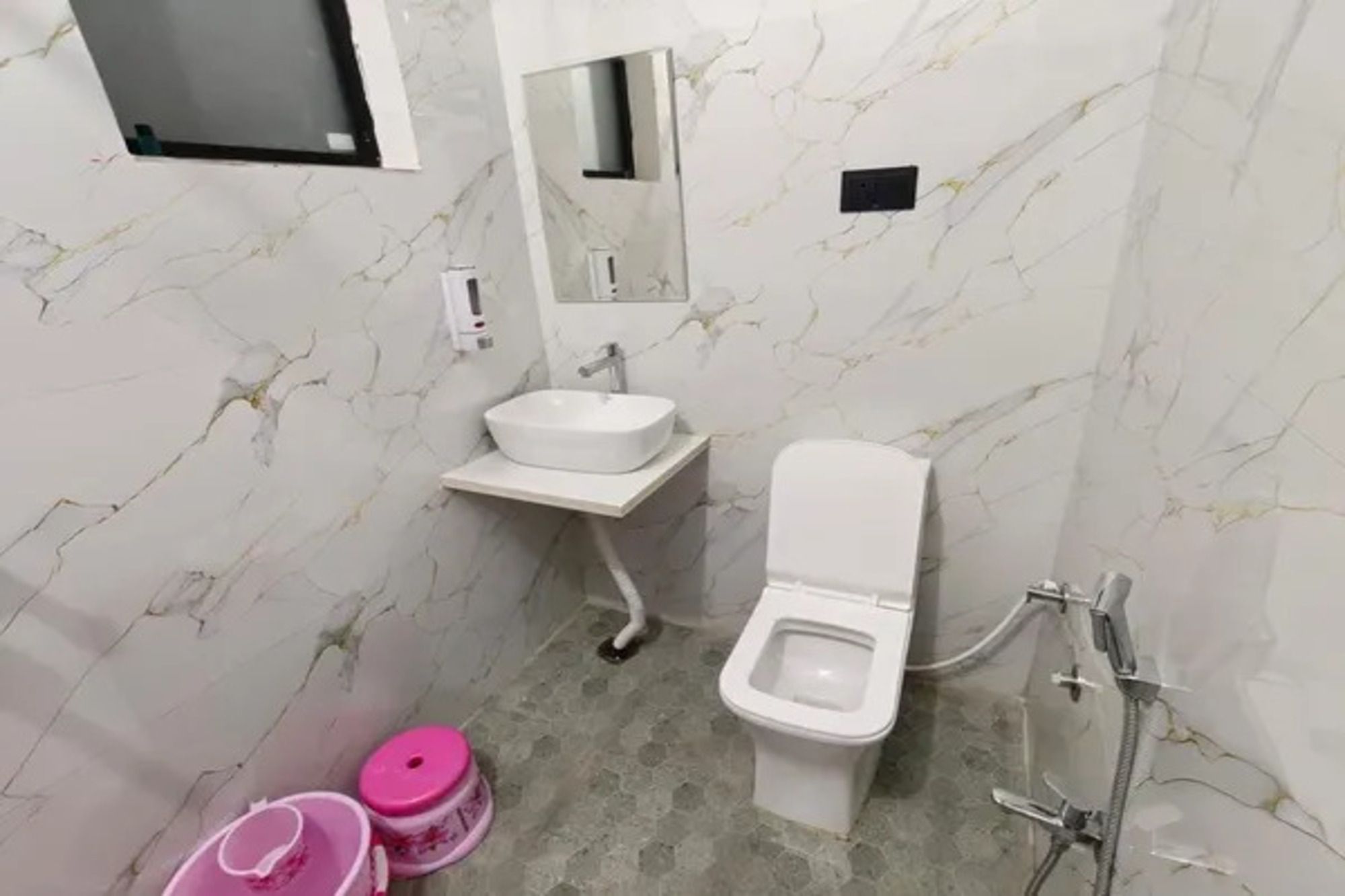 A bathroom with a toilet, sink, and mirror.