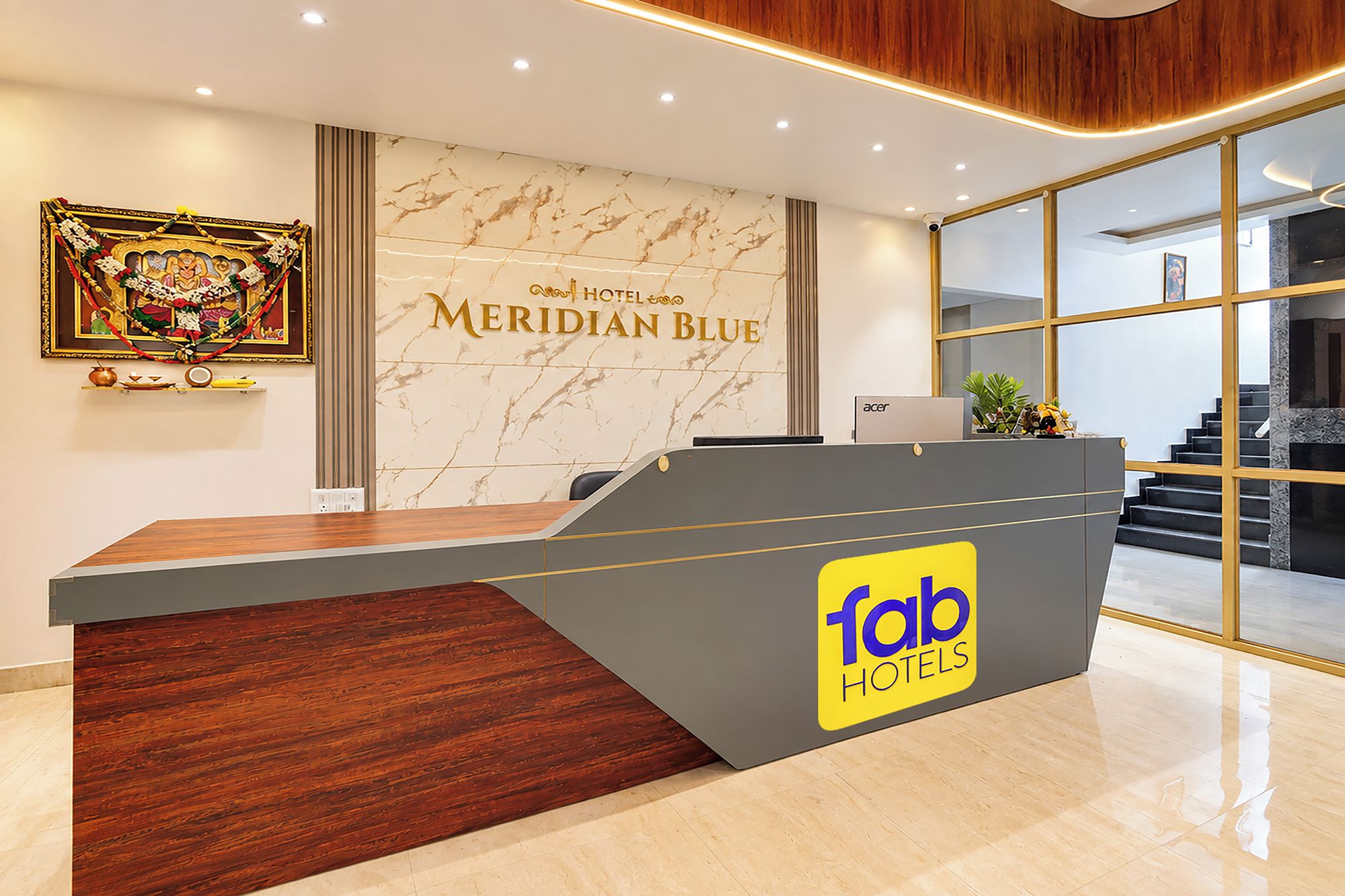 Mostrador de recepción de hotel con pared de mármol y un letrero que dice 'Meridian Blue'.