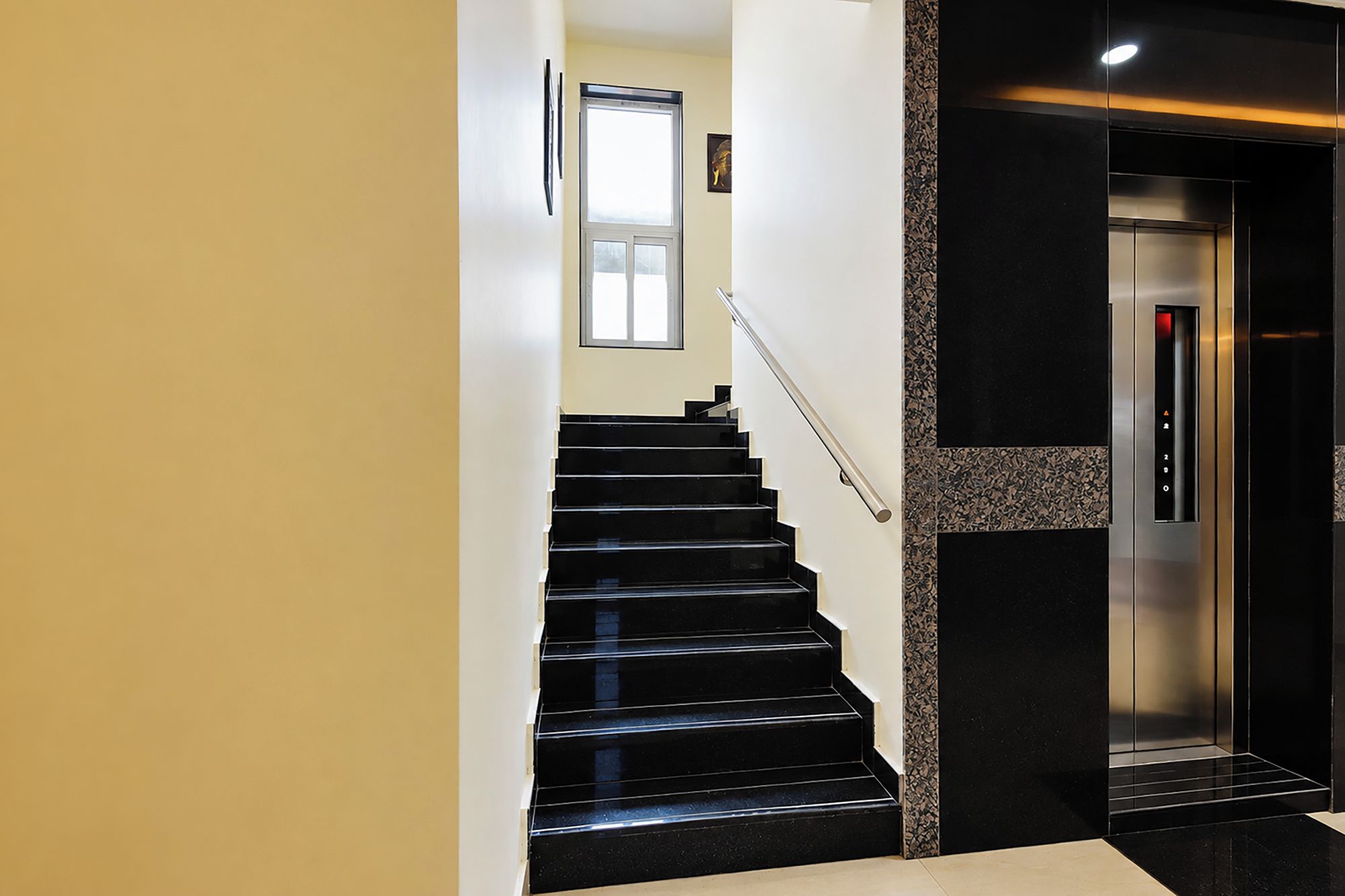 A modern interior with a staircase leading to an elevator.