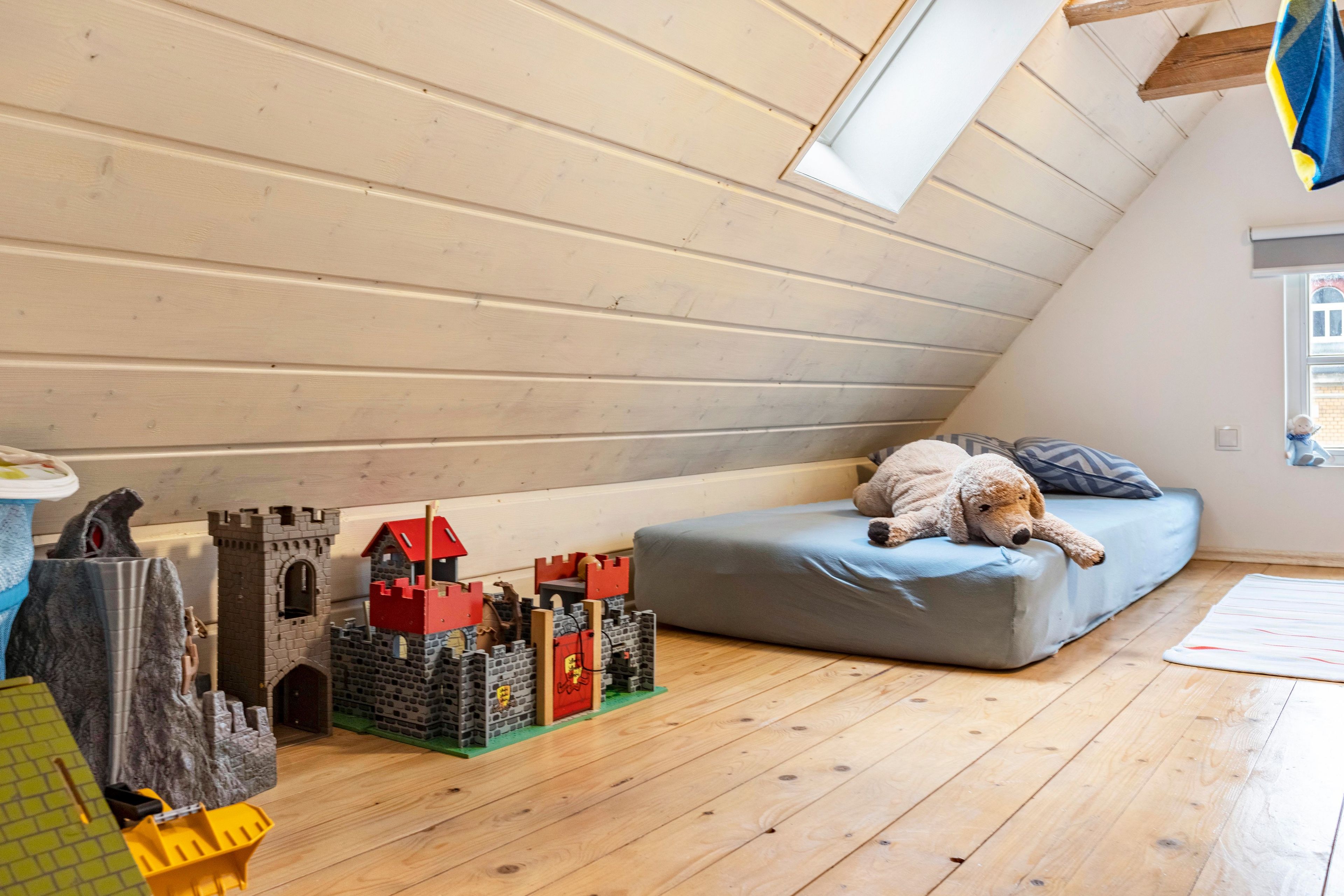 A child's play area with a castle model, a bed, and a dog.