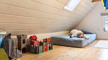 A child's play area with a castle model, a bed, and a dog.