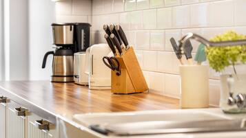 Una cocina con cafetera, tostadora y un bloque de cuchillos sobre la encimera.