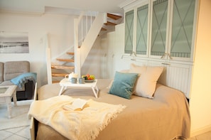 Ein Schlafzimmer mit Bett, Nachttisch und Blick auf eine Treppe.