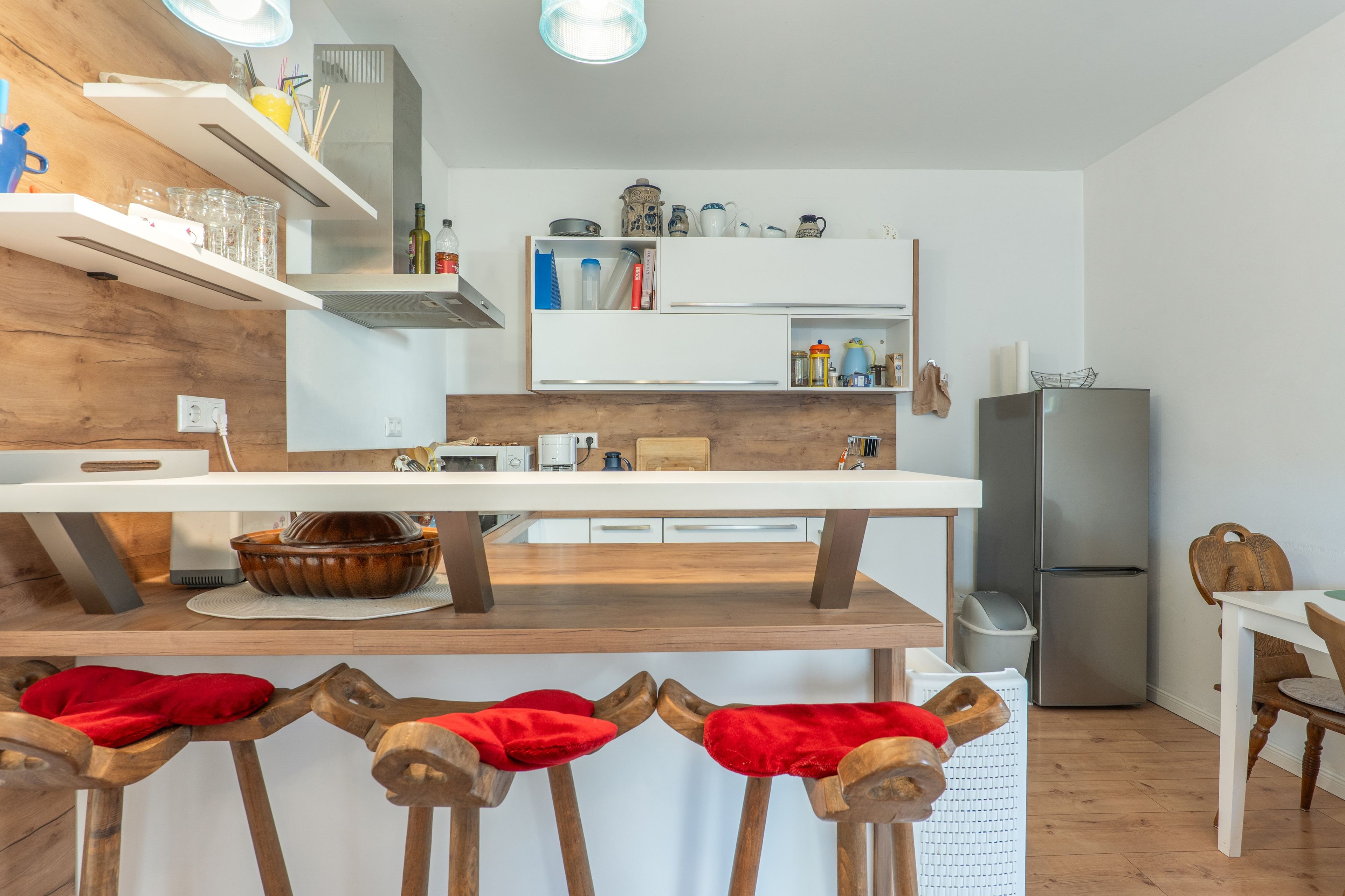 A modern kitchen with wooden countertops, a built-in oven, and a stainless steel refrigerator.