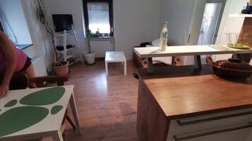 Una cucina moderna con piani di lavoro in legno, un tavolo da pranzo e un armadietto bianco.