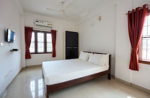 Ein Schlafzimmer mit Bett, Kleiderschrank, Deckenventilator, Klimaanlage und Fernseher.