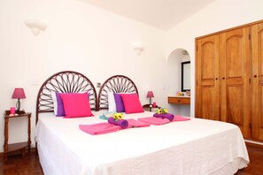 A hotel room with a bed, two bedside tables, a wardrobe, and a mirror. - Heatable pool & BBQ retreat in Carvoeiro (Carvoeiro)