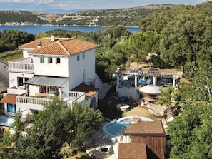 A two-story house with a swimming pool, surrounded by trees and a view of the sea. - Villa Agata Ground Floor With Pool & Sauna (Rab)