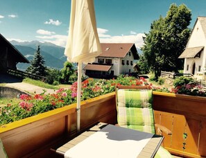 A balcony with a table, chairs, and a view of a mountain landscape. - Holiday Apartment With 1 Bedroom (Meltina)