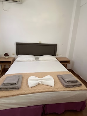 A hotel room with a bed, two nightstands, a lamp, and towels. - Studio Apartment 'Double Room - 202' with Sea View, Wi-Fi and Air Conditioning (Εμπορείο)