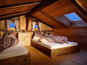 A cozy attic bedroom with two beds, a dresser, and a skylight. - Holiday Home in Schenna With Swimming Pool (Schenna)