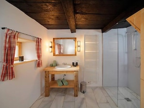 A bathroom with a wooden vanity, a mirror, a sink, and a shower. - Holiday Home in Schenna With Swimming Pool (Schenna)
