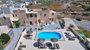 A hotel with a swimming pool surrounded by lounge chairs and umbrellas, a courtyard, and a view of the surrounding area. - Studio Apartment 'Double Room - 301' with Sea View, Wi-Fi and Air Conditioning (Εμπορείο)