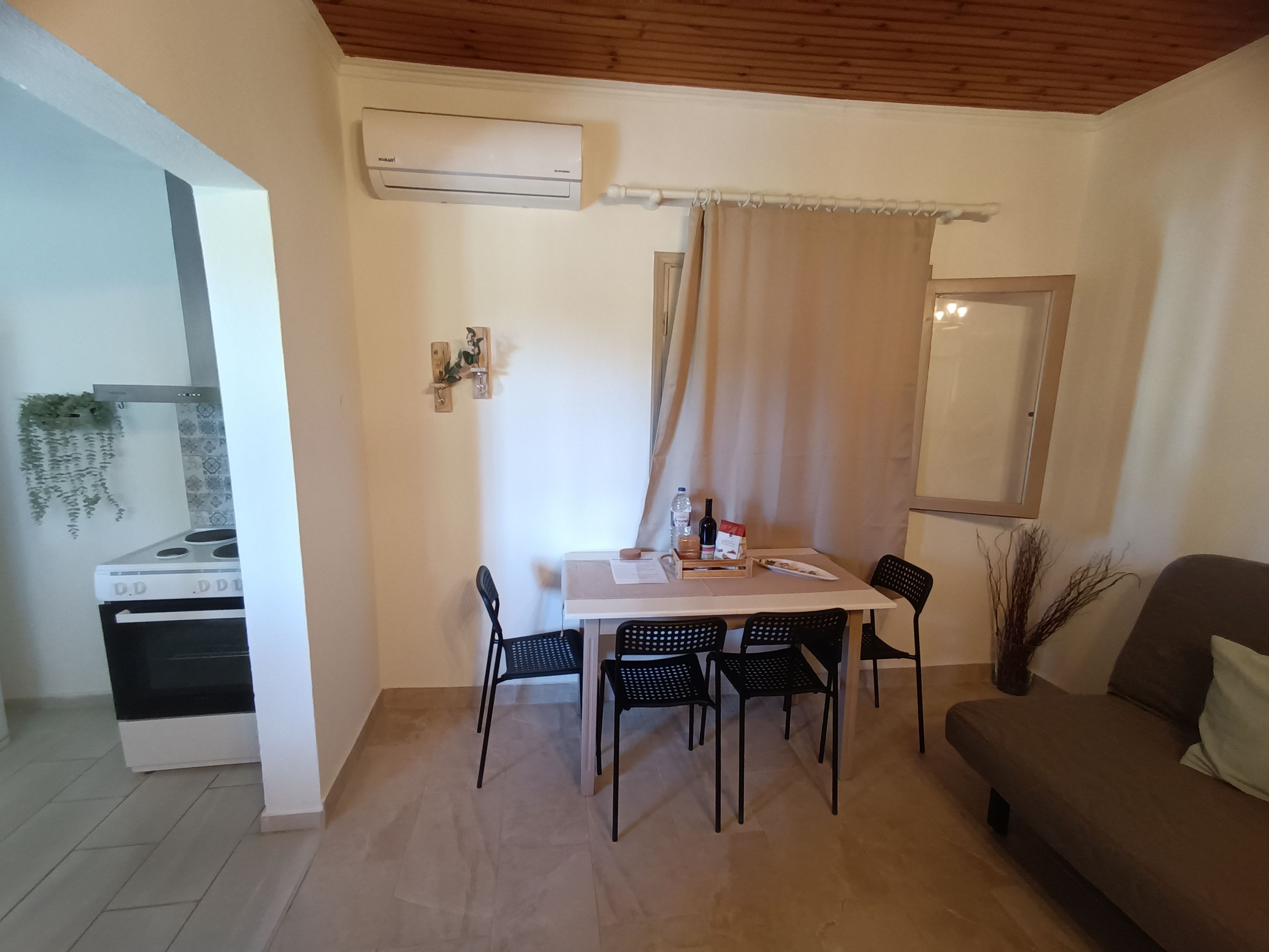 A dining area with a table, chairs, and an air conditioning unit.