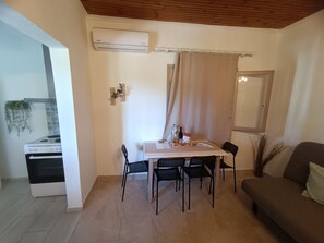 A dining area with a table, chairs, and an air conditioning unit.