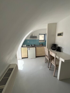 A compact kitchen with a dining area, featuring a built-in stove, a sink, and a window overlooking a scenic view. - Studio Apartment 'Double Room - 302' with Sea View, Wi-Fi and Air Conditioning (Εμπορείο)