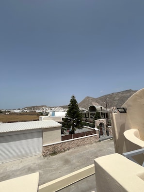 A rooftop terrace with a view of a mountain, a tree, and a building with a curved roof. - Studio Apartment 'Double Room - 302' with Sea View, Wi-Fi and Air Conditioning (Εμπορείο)