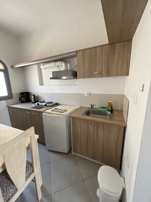 A compact kitchen with a built-in oven, a sink, and a small refrigerator. - Apartment 'Maisonette - 101' with Sea View, Wi-Fi and Air Conditioning (Εμπορείο)