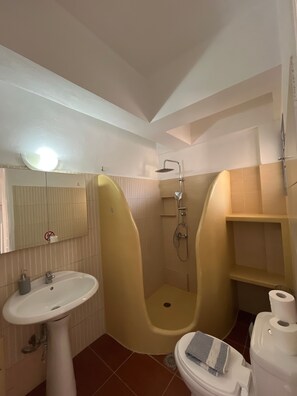 Ein Badezimmer mit Waschbecken, Toilette und Duschkabine.