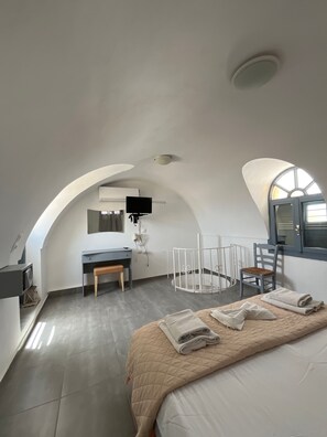 A bedroom with a bed, a desk, a chair, and a crib. - Apartment 'Maisonette - 101' with Sea View, Wi-Fi and Air Conditioning (Εμπορείο)
