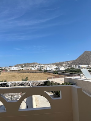 A view of a coastal town with white buildings, a mountain in the background, and a clear blue sky. - Apartment 'Maisonette - 201' with Sea View, Wi-Fi and Air Conditioning (Εμπορείο)