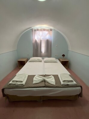 A single bed with a quilted headboard, two bedside tables, a lamp, and a window with curtains. - Apartment 'Maisonette - 201' with Sea View, Wi-Fi and Air Conditioning (Εμπορείο)