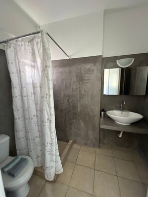A bathroom with a shower curtain, a sink, and a toilet. - Studio Apartment 'Triple Room - 103' with Sea View, Wi-Fi and Air Conditioning (Εμπορείο)