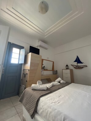 Ein Hotelzimmer mit einem Bett, einem Schminktisch, einem Spiegel, einer Heizung und einem Fenster.