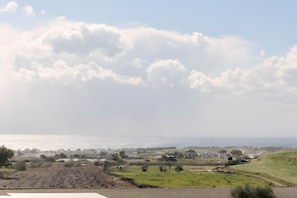 Eine Küstenlandschaft mit Feldern, einer Straße und Gebäuden in der Ferne.