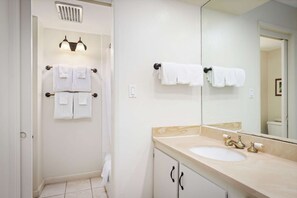 Ein Badezimmer mit Waschbecken, Spiegel, Handtuchhalter und Dusche.