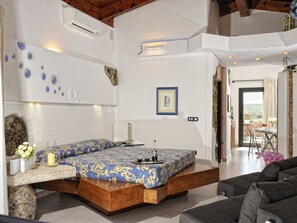 Ein modernes Schlafzimmer mit Bett, Nachttisch und Blick ins Freie.
