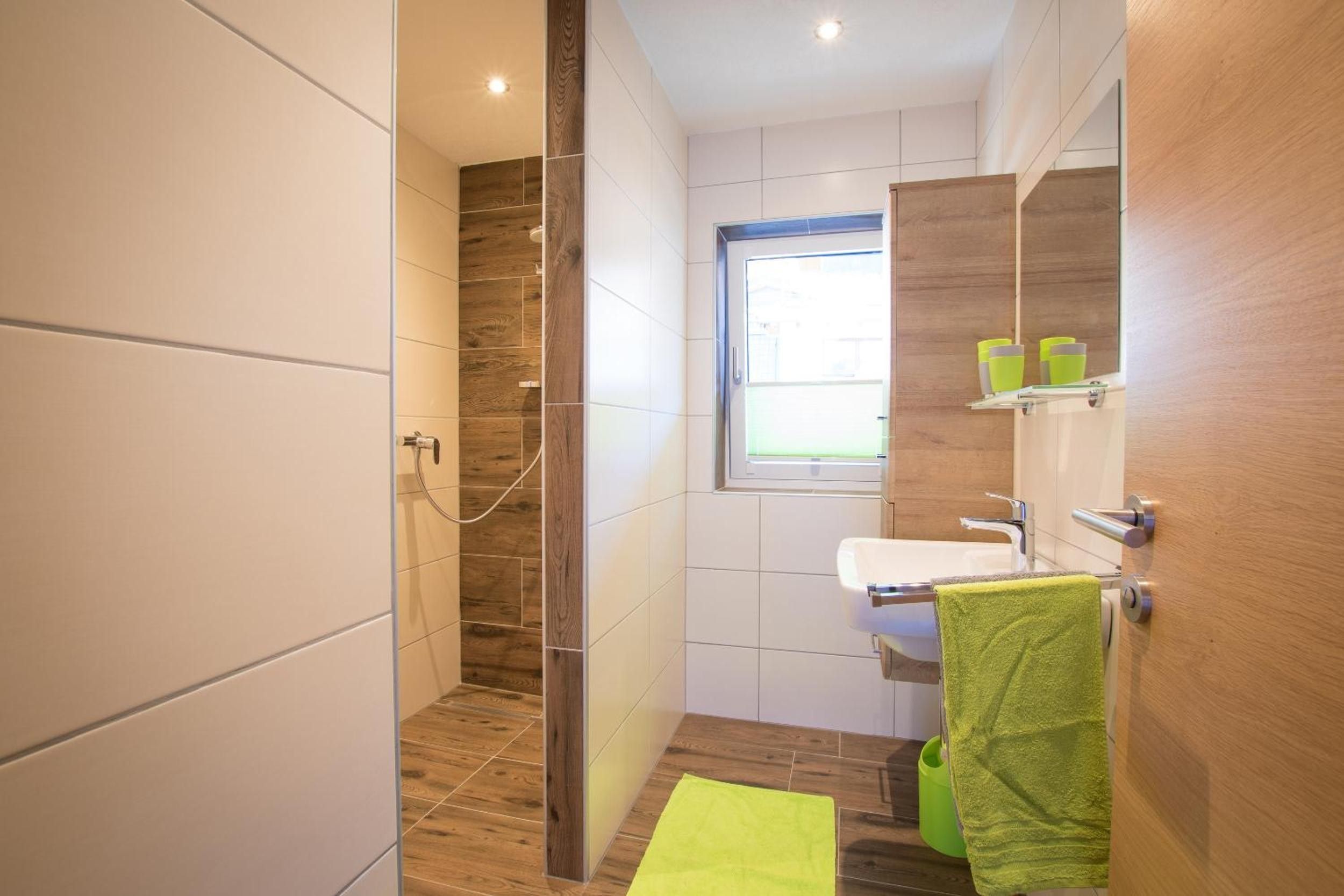 A modern bathroom with a shower, toilet, and sink.