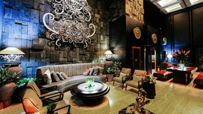 A modern lounge area with a sofa, armchairs, a coffee table, and decorative lamps. - Moonstone Luxury Villa (Badung)