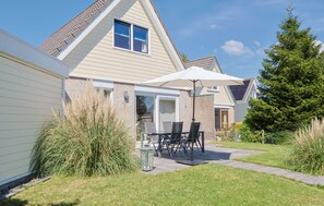 A residential house with a patio, a dining table with chairs, and a large umbrella. - Watersnip - Enjoying the water (Lemmer)