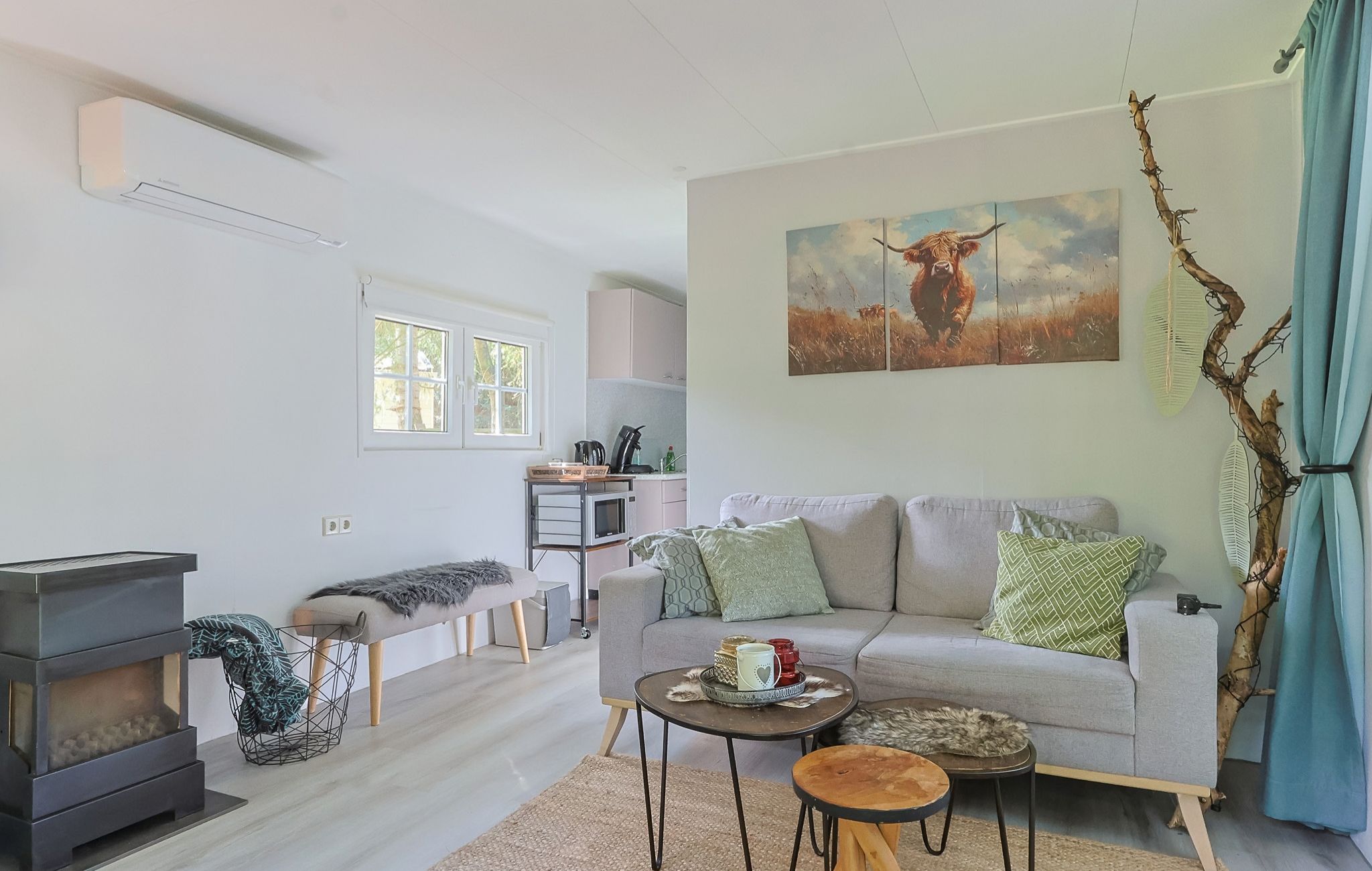 A modern living room with a sofa, a coffee table, a fireplace, and a painting of a deer.