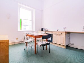 Eine kleine Küche mit Esstisch, Stühlen und einem Fenster.