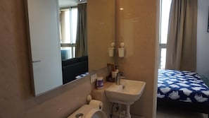 Une salle de bain avec un lavabo, un miroir et des toilettes.