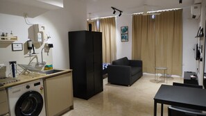 Un espacio habitable funcional con kitchenette, sofá y comedor.
