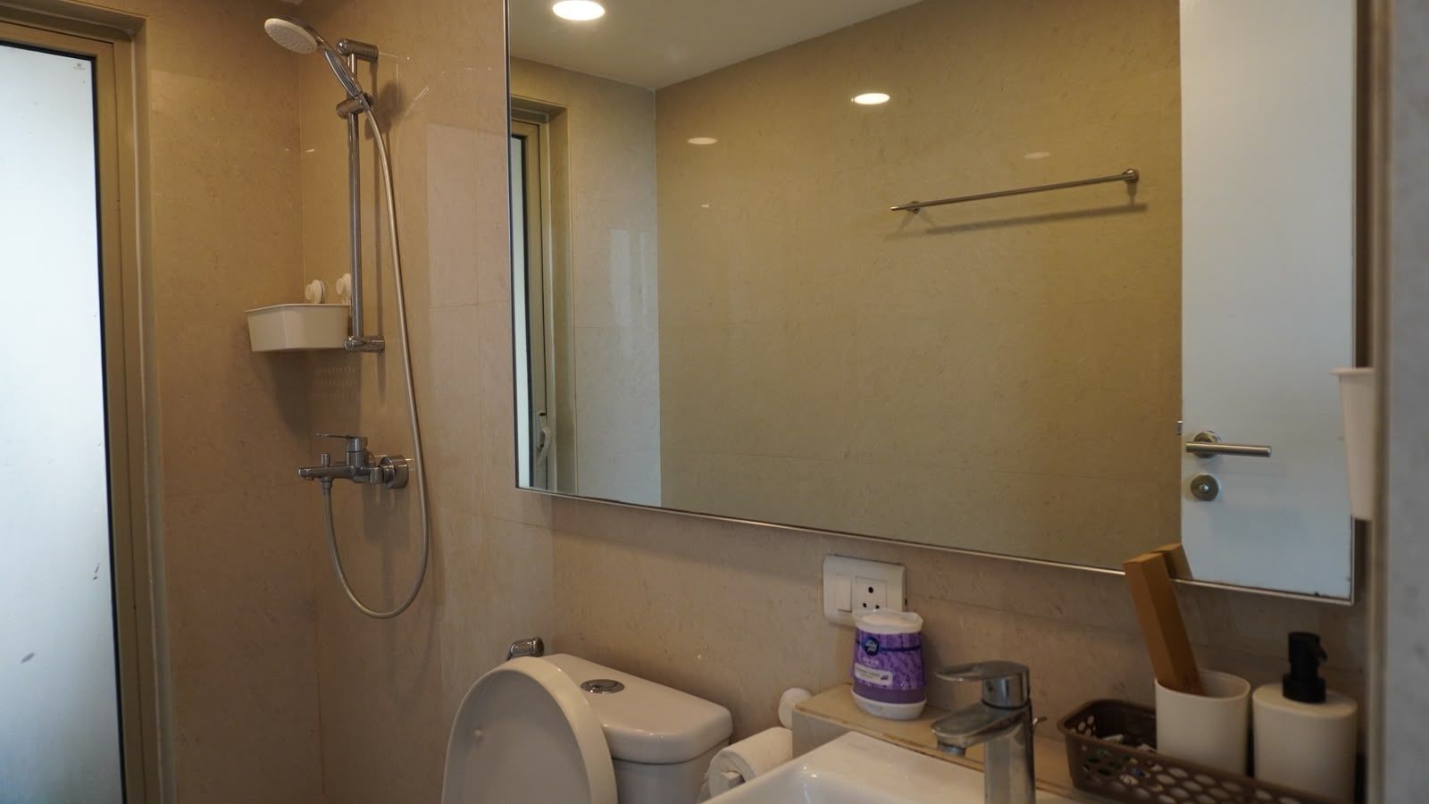 Un baño con ducha, inodoro, lavabo y espejo.