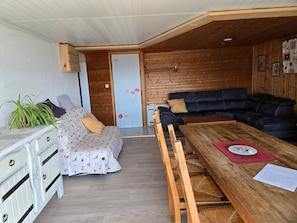 A cozy living area with a sofa, a dining table, and a wooden floor. - Apartment 'Charmant Vue Mont-Blanc' with Mountain View and Wi-Fi (Onnion)