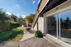 A modern house with a patio, a dining area, and a large sliding glass door.
