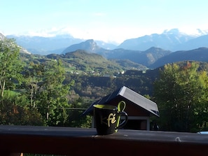 A mug with a design on a balcony overlooking a mountainous landscape. - Apartment 'Charmant Vue Mont-Blanc' with Mountain View and Wi-Fi (Onnion)