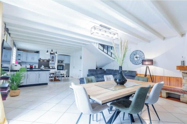A modern kitchen with a dining area, a staircase leading to an upper level, and a living room with a sofa and a lamp. - Bellevue Vacation Rental with Pool (3-star) (Agos-Vidalos)
