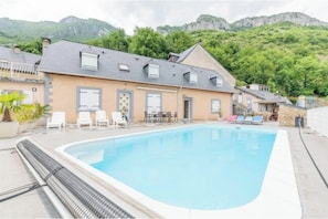 A swimming pool with lounge chairs and a building with a sloped roof. - Bellevue Vacation Rental with Pool (3-star) (Agos-Vidalos)