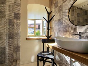 A bathroom with a large white sink, a mirror, and a window with a view of buildings. - Kalu With Pool Near Rovinj (Kanfanar)
