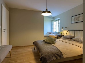 A bedroom with a bed, bedside table, lamp, and a window. - Kalu With Pool Near Rovinj (Kanfanar)