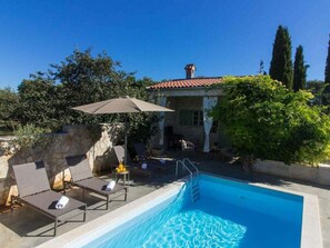 A swimming pool with lounge chairs and an umbrella, surrounded by stone walls and vegetation. - Kalu With Pool Near Rovinj (Kanfanar)